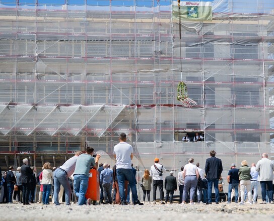 Viele Menschen stehen mit dem Rücken zur Kamera und schauen auf ein Gebäude | © Magistratspressestelle / Arnd Hartmann
